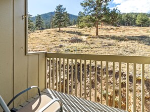 A balcony with a view of a dry grass field and trees, a metal railing, and a bench. - Deer Mountain Retreat 3bdr townhouse near Fall RiverRocky Mountain National Park (Estes Park)