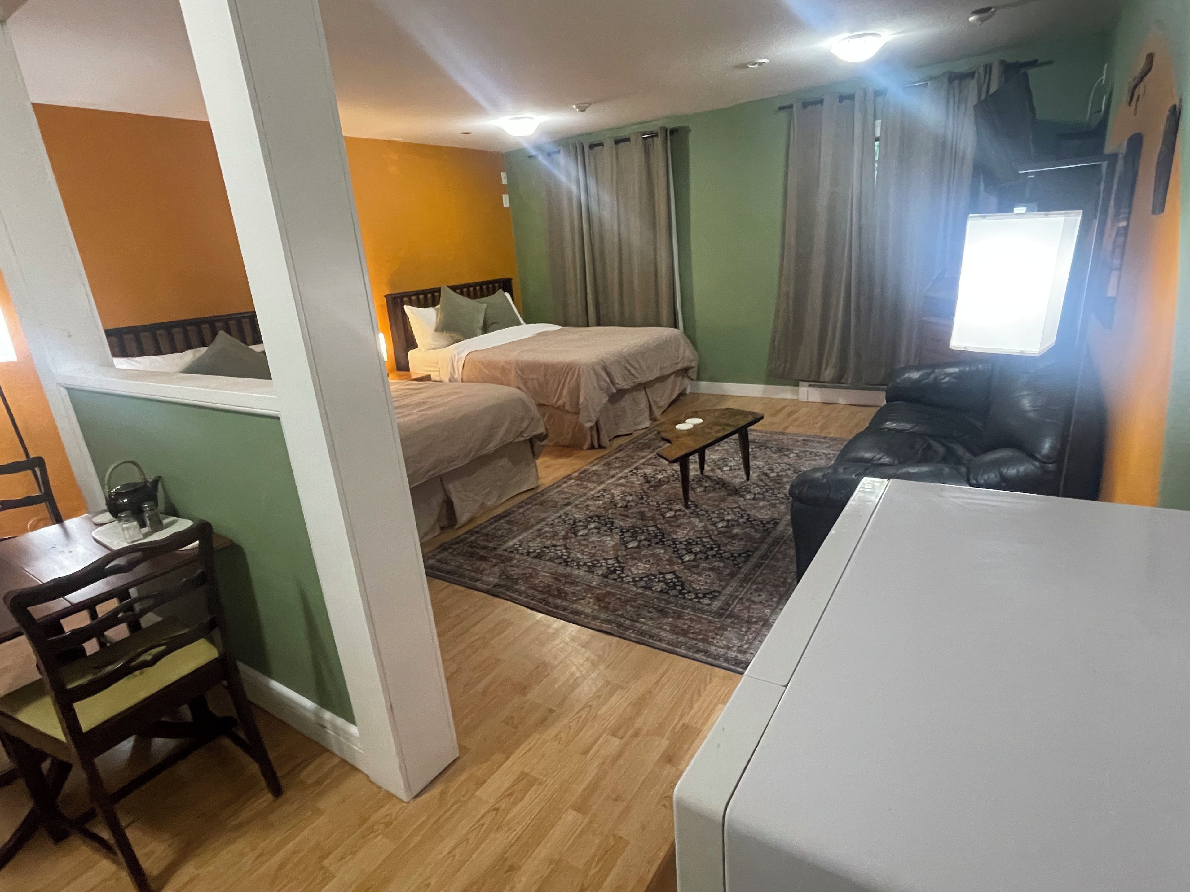 A room with two beds, a sofa, a small table, and a chair.