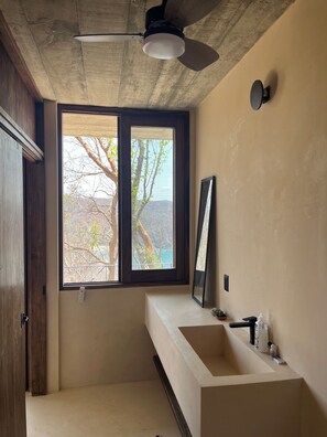 A bathroom with a large window, a ceiling fan, and a built-in sink. - Luxury Villa Xololo on the secluded beach of La Boquilla, Oaxaca, Pacific Coast (San Pedro Pochutla)