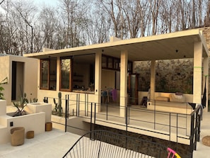 A modern house with a covered patio, a stone wall, and a cactus garden. - Luxury Villa Xololo on the secluded beach of La Boquilla, Oaxaca, Pacific Coast (San Pedro Pochutla)