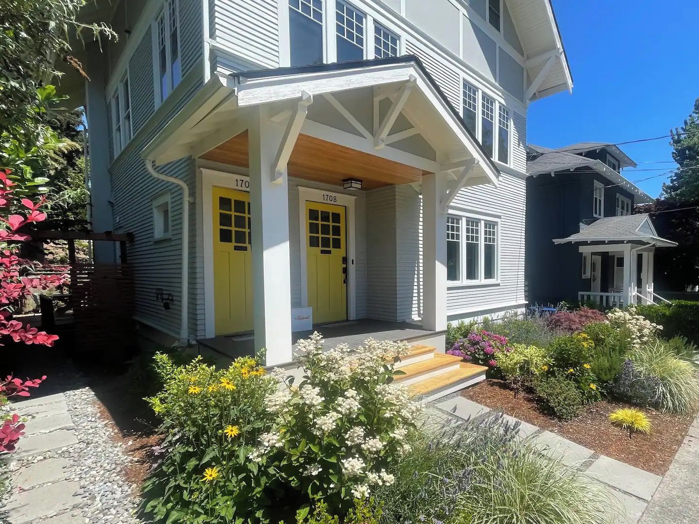 A two-story house with a porch and a front yard.