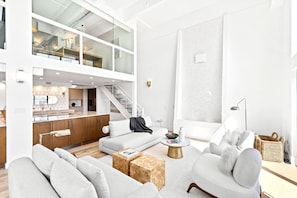 Ein modernes Wohnzimmer mit einer Couch, einem Couchtisch und einer Treppe, die in eine obere Etage führt.