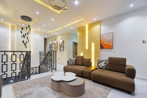 A modern living room with a sofa, coffee table, and decorative wall art. - Charming 3-bedroom apartment with AC in  Lagos (Lagos)
