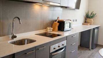 Una cocina moderna con electrodomésticos de acero inoxidable, horno empotrado y microondas.