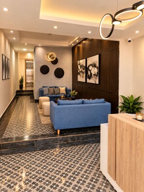 Ein modernes Wohnzimmer mit einem blauen Sofa, einem Couchtisch und Kunstwerken an der Wand.