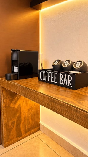 A coffee bar with a sign, a coffee machine, and coffee capsules. - Bowra Suite Privada 7, Colonia Americana (Guadalajara)