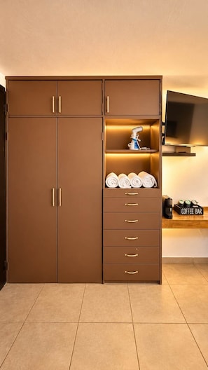 A brown wardrobe with multiple drawers and a shelf with towels. - Bowra Suite Privada 7, Colonia Americana (Guadalajara)