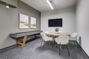 A conference room with a pool table, a round table with chairs, and two framed artworks on the wall. - The Sage Loft at The Highlands, a curated 2BR/2BA executive suite | Gym & Sauna (St. Thomas)