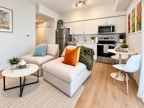 Een modern appartement met een woonkamer, keuken en een eethoek.