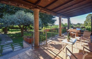 An outdoor patio with a wooden pergola, outdoor furniture, and a view of a garden with trees and plants. - Lovely home in Campagnano with private swimming pool, can be inside or outside (Campagnano)