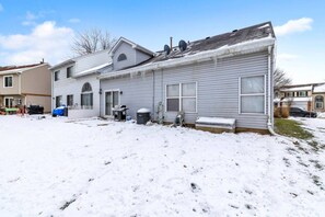 A residential house with a garage, a covered patio, and a snow-covered yard. - 4BR Family Home • Ideal for Insurance & Work Stays (Lake in the Hills)