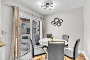 A dining area with a round table, four chairs, and a ceiling light fixture. - 4BR Family Home • Ideal for Insurance & Work Stays (Lake in the Hills)