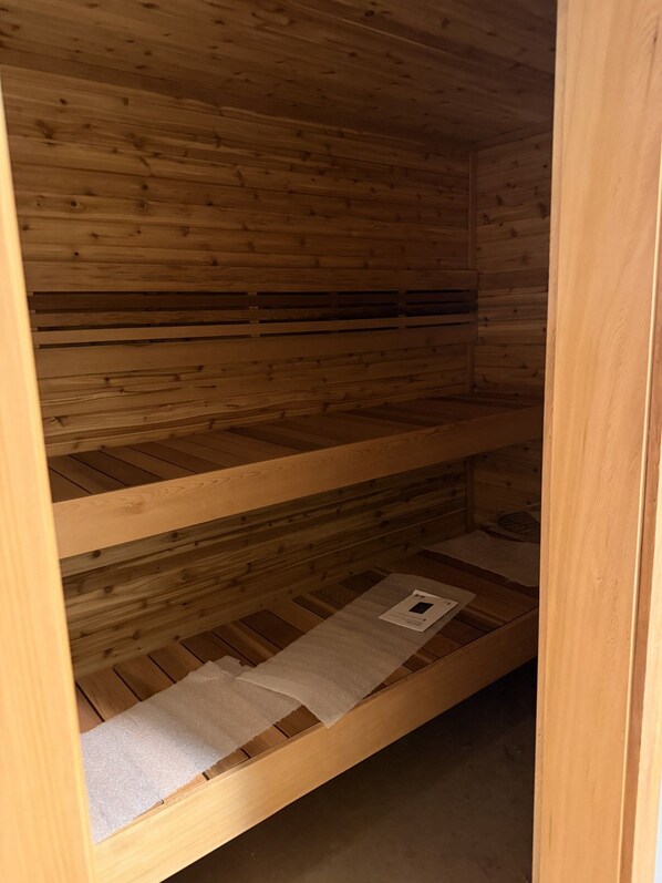 Una cama litera de madera con un colchón y un pequeño papel en el estante inferior.