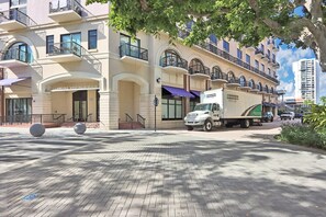 Un hôtel à plusieurs étages, doté d’une entrée imposante, avec un camion garé devant et un ciel dégagé.
