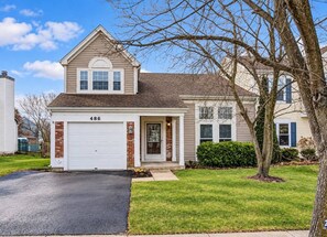 A two-story house with a garage, numbered 486, and a well-maintained lawn. - Furnished 3BR Home | Fenced Yard | Mid-Term (Grayslake)
