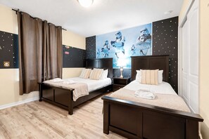 Ein Doppelzimmer mit zwei Betten, dunklem Holzvertäfelung, einer Wand im Stil von Star Wars und einem Star Wars Poster.