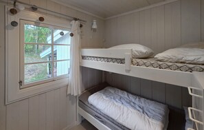 A bunk bed room with a window, curtains, and a lamp. - Stunning home in Melsomvik with harbor view (Melsomvik)