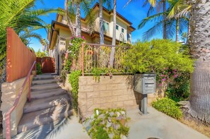 A two-story house with a stone wall, a metal gate, and a mailbox. - La Jolla Beach House -  Walk to Windansea, EV Charger (San Diego)