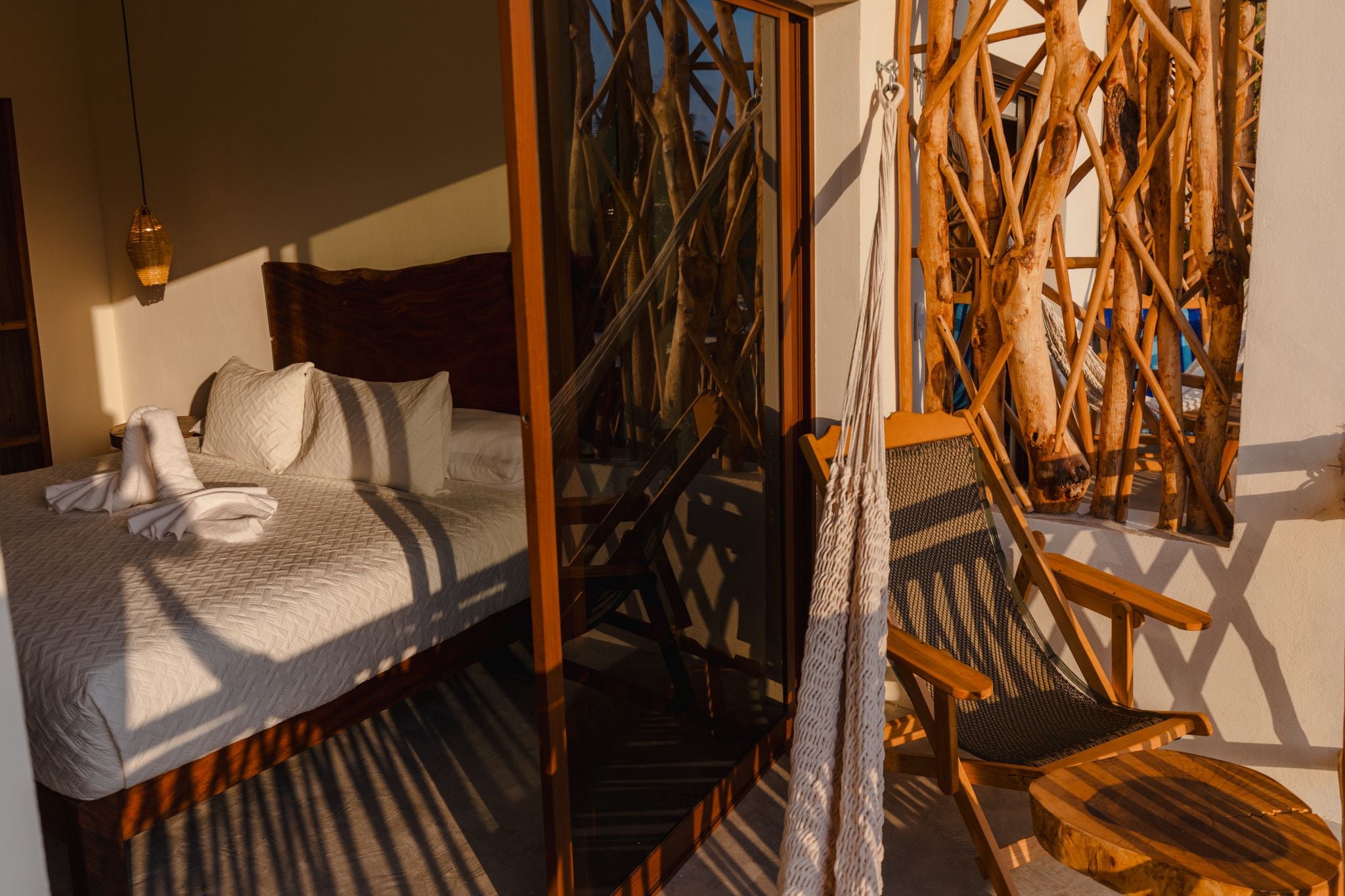 Una habitación con una cama, una silla y una estructura tejida.