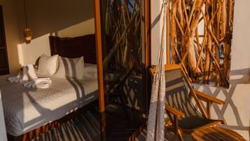Una habitación con una cama, una silla y una estructura tejida.
