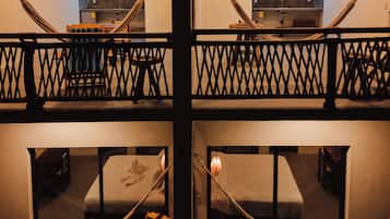 Une chambre d’hôtel à plusieurs niveaux, dotée d’un balcon, de hamacs et d’un coin cuisine.