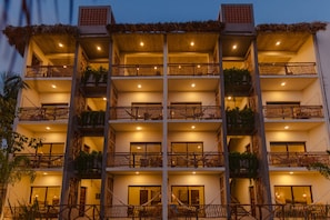 A multi-story hotel with balconies, each with a wooden railing and potted plants. - Hotel Almendros Bonfil (Acapulco de Juárez)