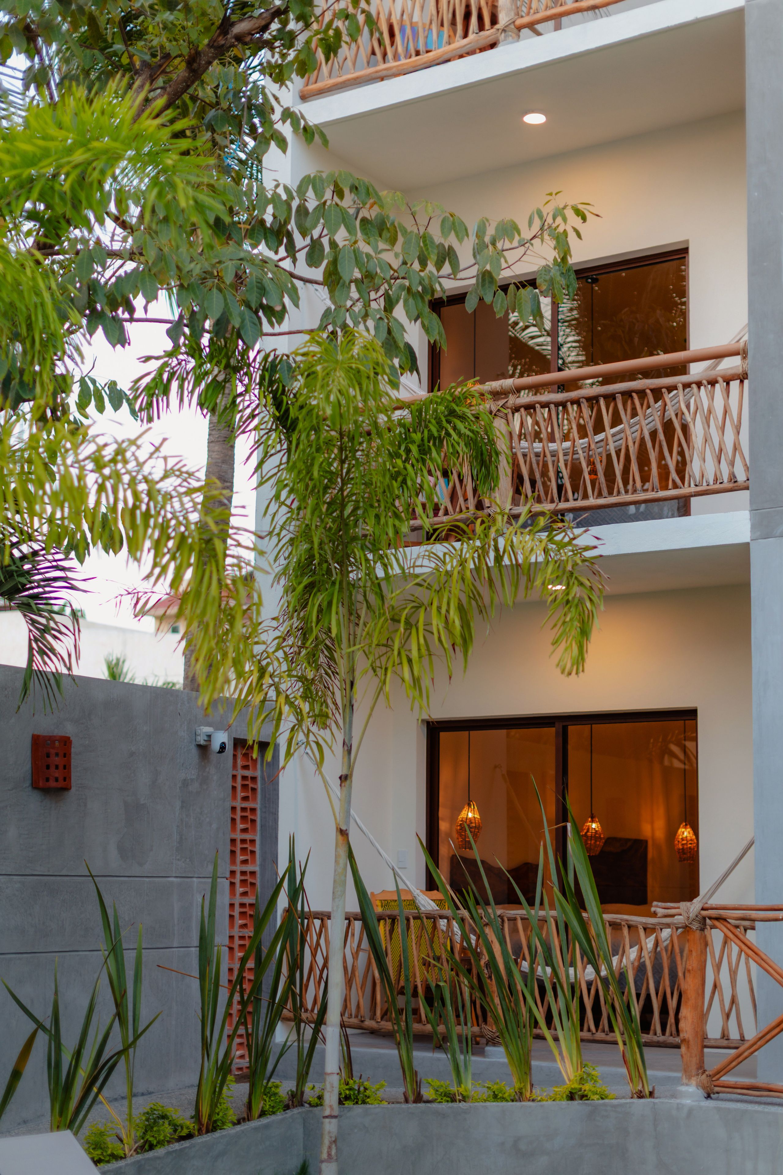 A modern building with a balcony, large windows, and a concrete wall.
