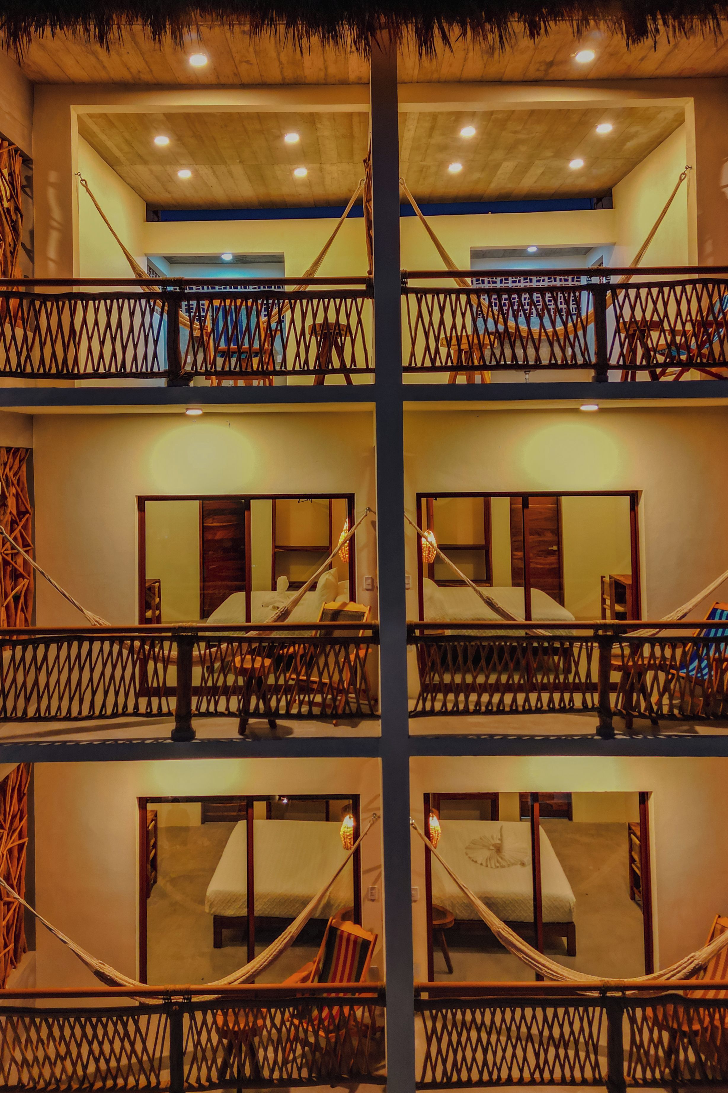 A multi-level hotel with balconies, wooden railings, and a central column.