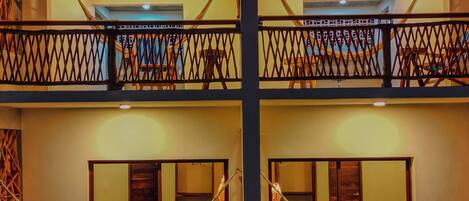 A multi-level hotel with balconies, wooden railings, and a central column.