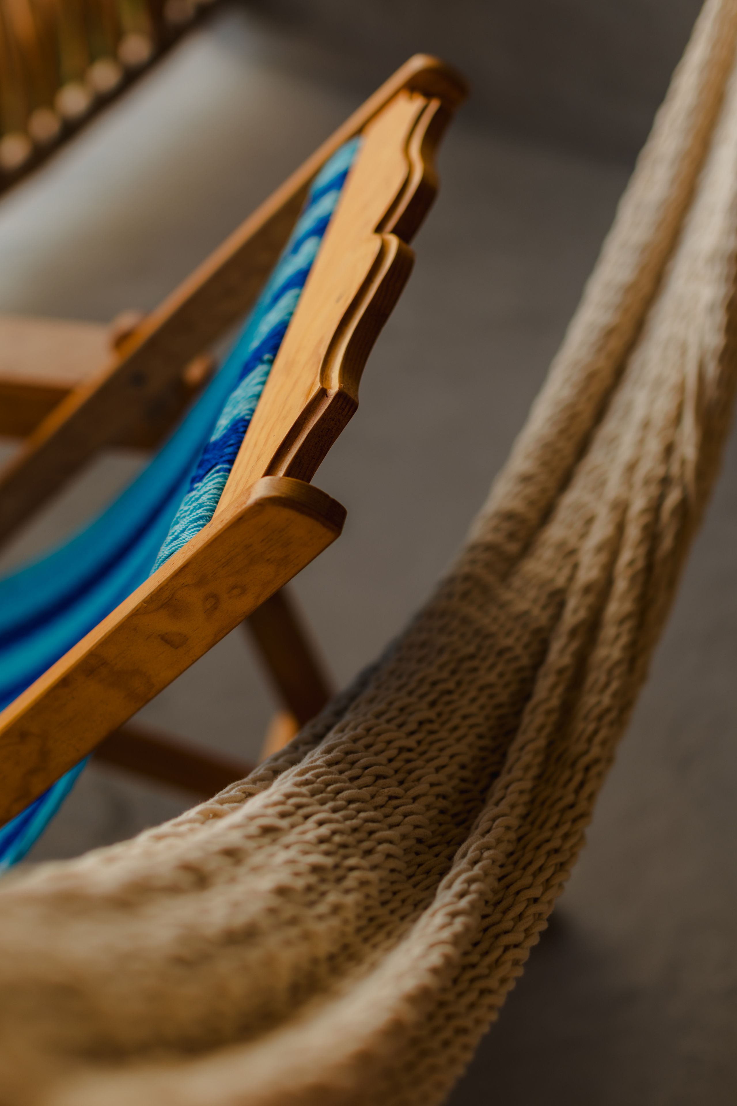 Primer plano de una silla de madera con un cojín azul estampado.