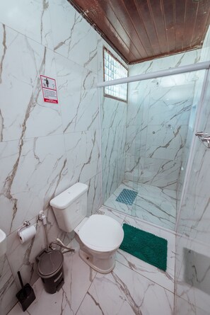 Ein Badezimmer mit Dusche, Toilette und Bidet.