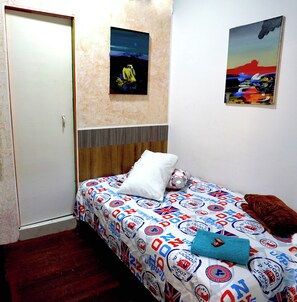 A bedroom with a bed, a door, and two paintings on the wall. - Hotel Arte  (SANTA ROSA DE CABAL)