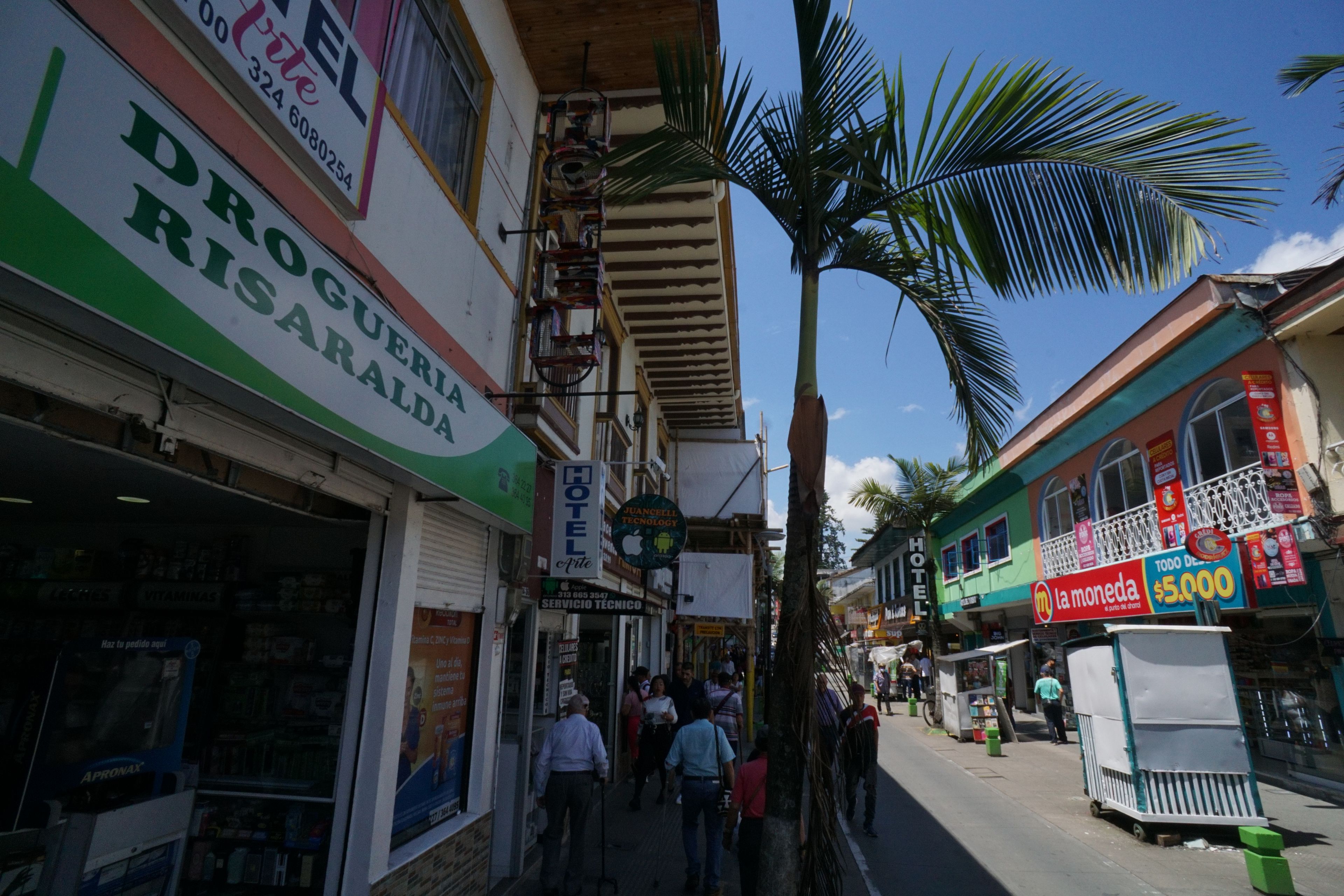 Vista de la calle con un hotel, una farmacia y un restaurante.