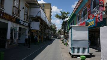 Una calle con edificios, incluyendo un hotel con un cartel que dice 'HOTEL' y una tienda con un cartel que dice 'AMIGA'.