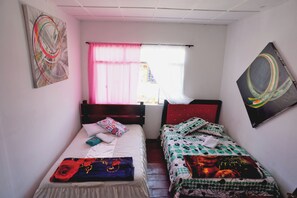 A room with two single beds, a window with pink curtains, and a painting on the wall. - Hotel Arte  (SANTA ROSA DE CABAL)