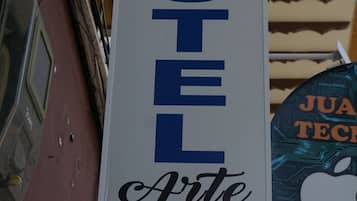 Un letrero de hotel con el nombre 'Hotel Arte' en letras azules grandes sobre un fondo blanco.