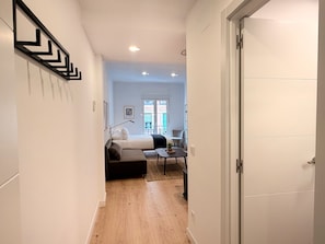 A hotel room with a bed, a desk, a chair, and a view of the outside. - Monteleón Apartments by Wynwood (Madrid)