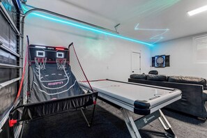 A room with a basketball court, a dartboard, and a sofa. - Outlaw Rest | Hot Tub, Pickleball, Views, Game Room, Poker, Grand Canyon (Williams)