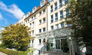 Ein mehrstöckiges Hotel mit Glastür und blauem Himmel.