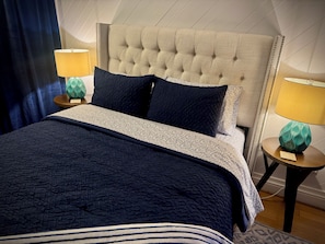 A bed with a tufted headboard, two bedside tables with lamps, and a patterned bedspread. - Boutique Surf Hideaway Steps from the Pacific (Manhattan Beach)