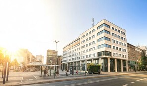 Ein mehrgeschossiges Gebäude mit moderner Architektur, gekennzeichnet durch eine große Glasfassade und ein Flachdach.