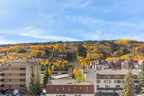 A residential area with buildings and a hillside covered in autumn foliage. - Vantage Point 309 - Heart of Lionshead, Walk to slopes (Vail)
