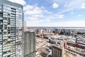 A high-rise building with a glass facade, a view of a cityscape, and a river in the background. - Charming 2-bedroom apartment with AC in lovely Montréal (Montréal)