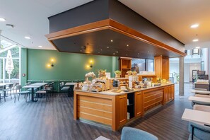 Ein modernes Café mit einer zentralen Holztheke, Sitzbereich und Blick ins Freie.