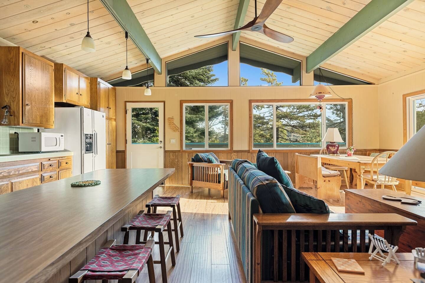 A spacious kitchen with wooden cabinets, a central island, and a dining area with a bench and table.