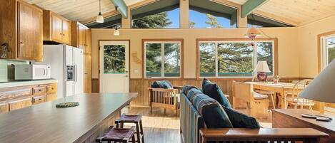 A spacious kitchen with wooden cabinets, a central island, and a dining area with a bench and table.