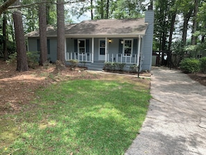 A residential house with a front porch, a driveway, and a lawn. - Cozy Lake House 2 (Macon)