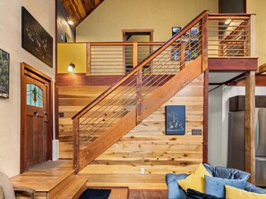 Un escalier en bois avec une rampe métallique menant à un niveau supérieur.