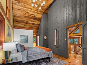A bedroom with a bed, a nightstand, a lamp, and artwork on the wall. - Private 30-Acre Retreat w/ Hot Tub, Game House/Pool Table, Trails & Pet Friendly (Old Fort)