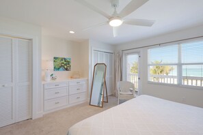 A bedroom with a bed, a dresser, a mirror, and a ceiling fan. - Gulf-Front Bliss | Soothing Waves, Breathtaking Sunsets & the Peaceful Charm of Boca Grande (Boca Grande)